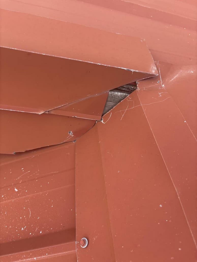 Sample report photo — garage corner, metal does not meet, wood in the hole