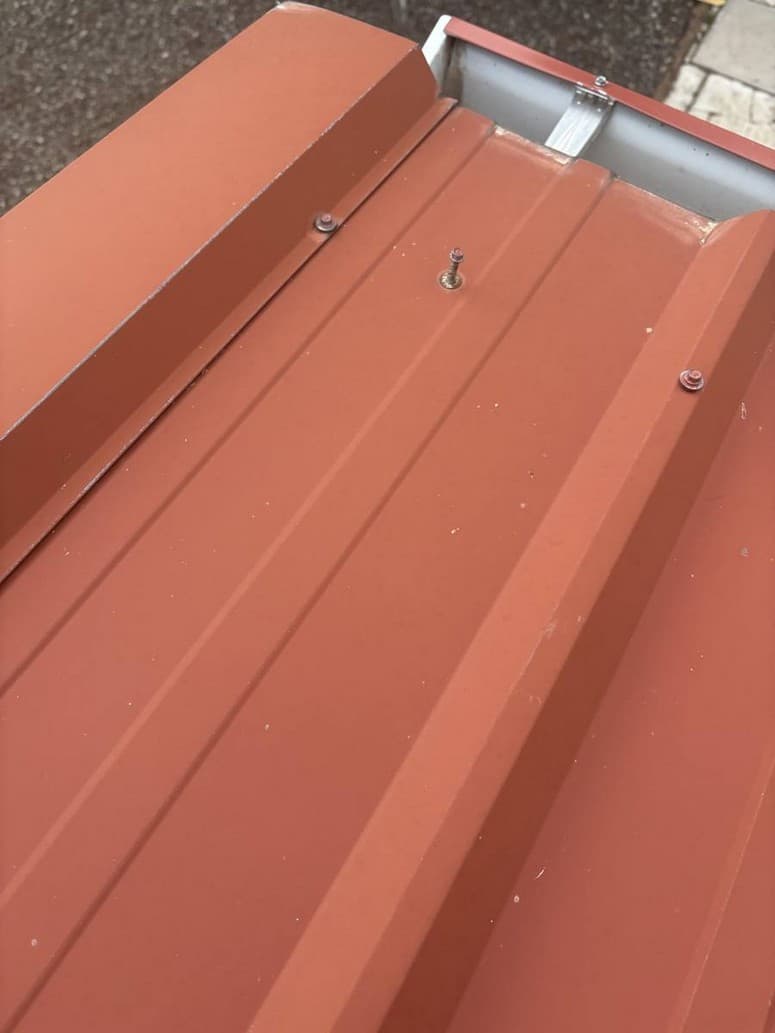 Screw standing up on a metal roof, threads showing