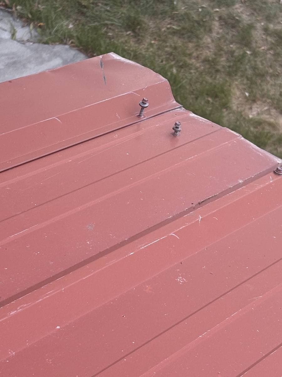 Photo 9 — Two screws standing up at the end of the trim. Trim is creased.